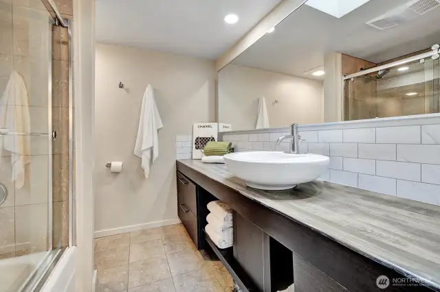 Full bath with tile shower/glass doors, lg vanity, marble floors.