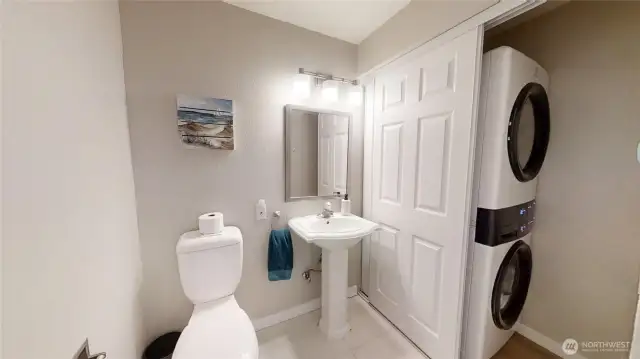 Main floor half bath with stackable laundry connections.
