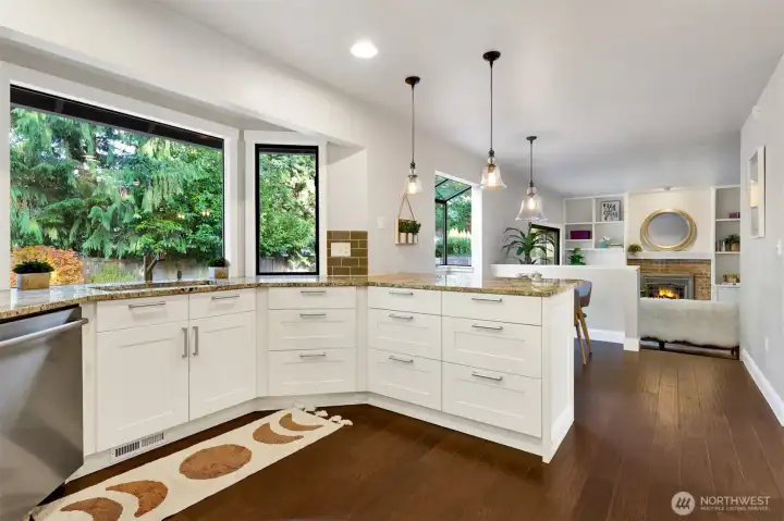 The kitchen has giant windows that look into the backyard.