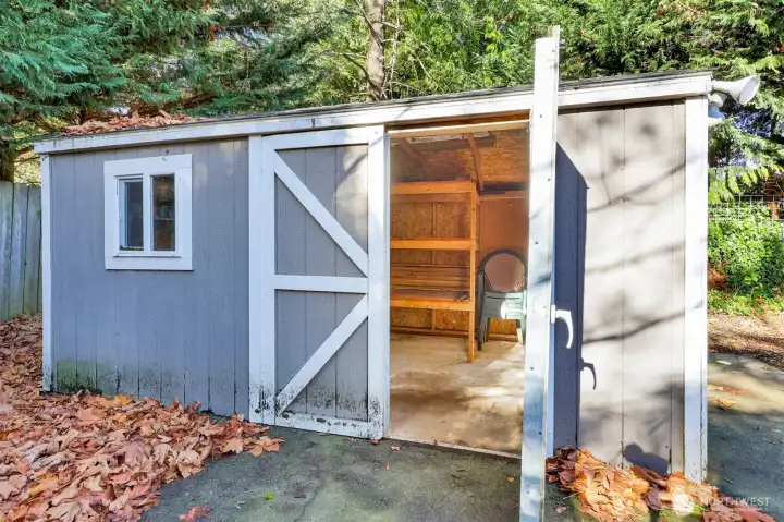 Shed in backyard has plenty of storage.