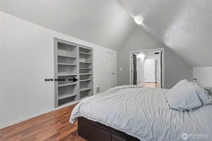 Upstairs Primary bedroom, love the cathedral ceilings throughout the upstairs, and this large master features a bonus room right next door, PLUS a safe room! Just push on this lower right-hand section of the bookcase.