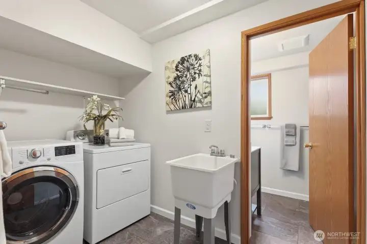Spacious laundry room with freestanding wash basin.