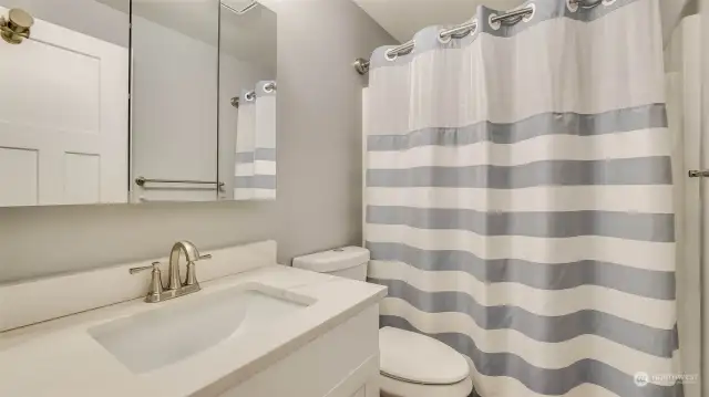 Updated upper level full bath with quartz counters and situated next to the guest bedrooms.