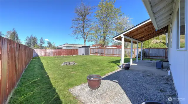 Fully fenced backyard with a expansive covered patio, storage shed and backs a new elementary that's in the award wining Puyallup School District.