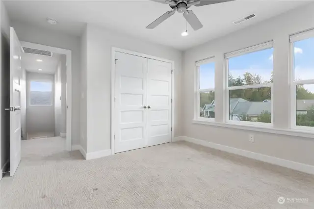 Upstairs bedroom facing the street with large windows.