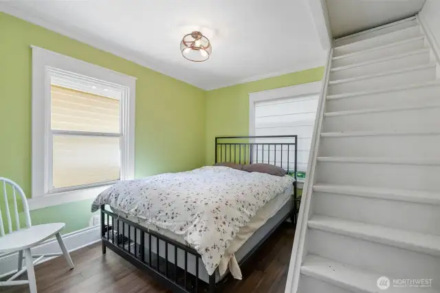 Main level bedroom with stair to attic for storage