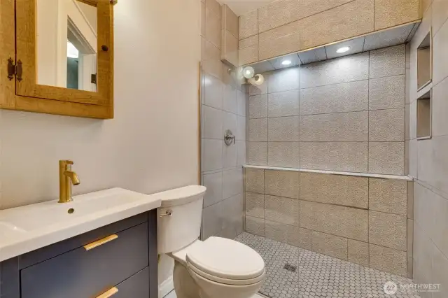 basement 3/4 bathroom with fully tiled shower and glass partition