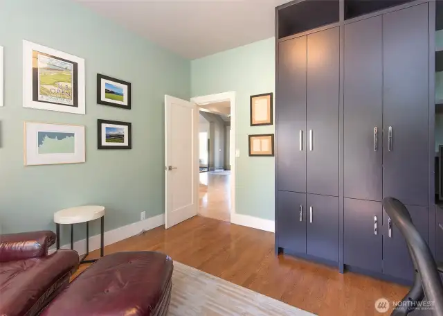 A main floor office with thoughtfully designed built-in cabinetry and ample storage provides the perfect workspace, combining practicality with refined design.