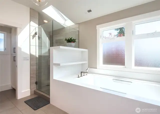 The primary bathroom offers a water closet, a luxurious soaking tub, a double vanity, and built-in linen storage, creating a spa-like retreat with plenty of space and functionality.
