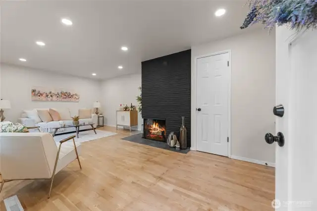 Charming entry with original hardwood flooring, fireplace and updated lighting