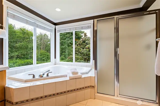 Primary bath soaking tub & shower with private windows looking out at the beautiful trees!