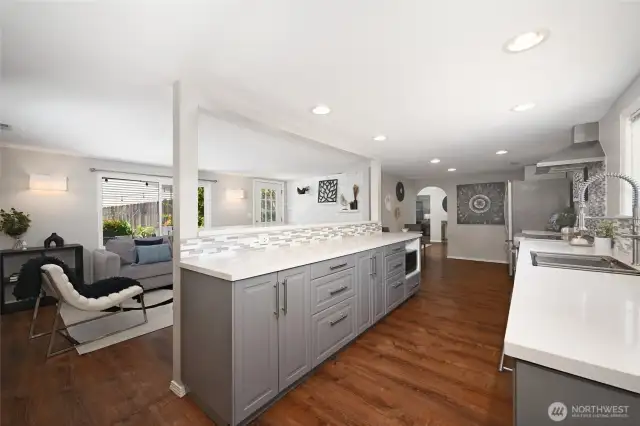 Chef's kitchen with stainless steel appliances, Corian countertops, and breakfast bar.