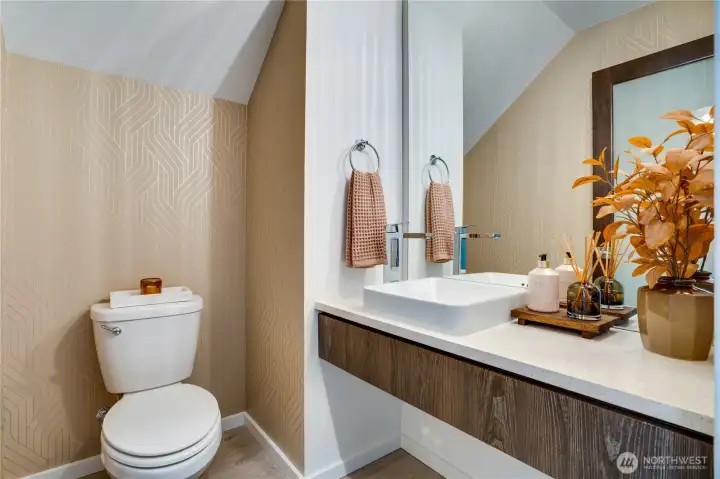 Main-floor powder room refreshed with stylish new wallpaper and sleek floating vanity.