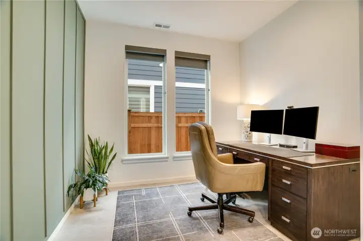 Elegant main-floor office with textured accent wall and crisp, curated details.