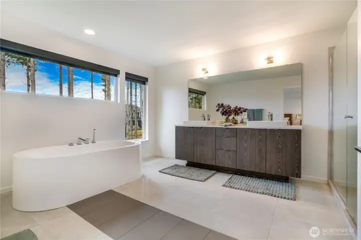 Luxury primary en-suite: spa-like with dual vanities, oversized walk-in shower and deep soaking tub.
