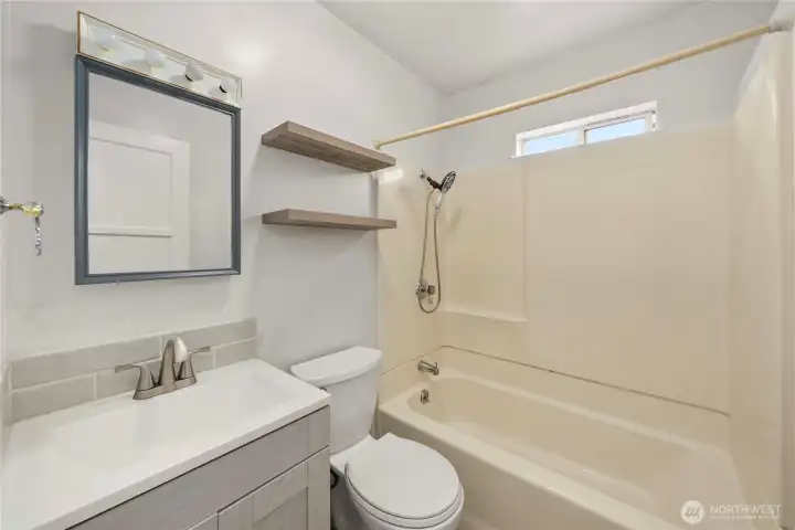 Full bath located between the two bedrooms with updated vanity, mirror, and toilet.