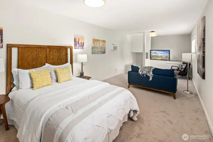 Another view of the upstairs bedroom showing a TV/reading area and extra storage to the far right.