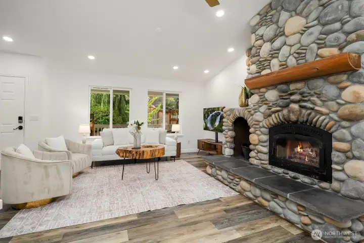 The stunning stone fireplace takes center stage in this beautifully updated living room, where fresh paint, new interior doors, and warm bamboo flooring come together to create a space that is truly move-in ready.