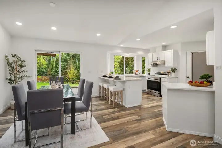 The open layout connects the dining area and well-appointed kitchen seamlessly, with quartz countertops, abundant storage, and a wall of windows overlooking the large patio and backyard making this space as functional as it is inviting.