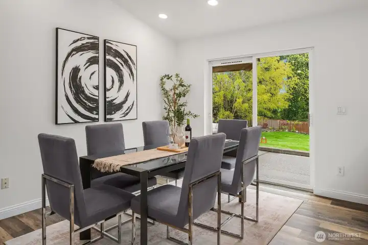 The dining area is bathed in natural light from large sliding doors that open directly to the expansive patio, creating an effortless indoor-outdoor flow perfect for weekend gatherings and al fresco entertaining.