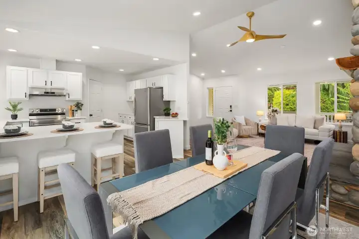 This view captures the wonderful connectivity of the main living spaces, with the dining area, kitchen, and living room flowing together under recessed lighting and vaulted ceilings to create a bright, open feel ideal for entertaining.