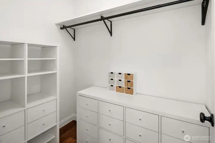 A generous walk-in closet offers excellent built-in storage with custom shelving and a large dresser, providing the kind of thoughtful organization that makes everyday living effortlessly comfortable in this move-in ready home.