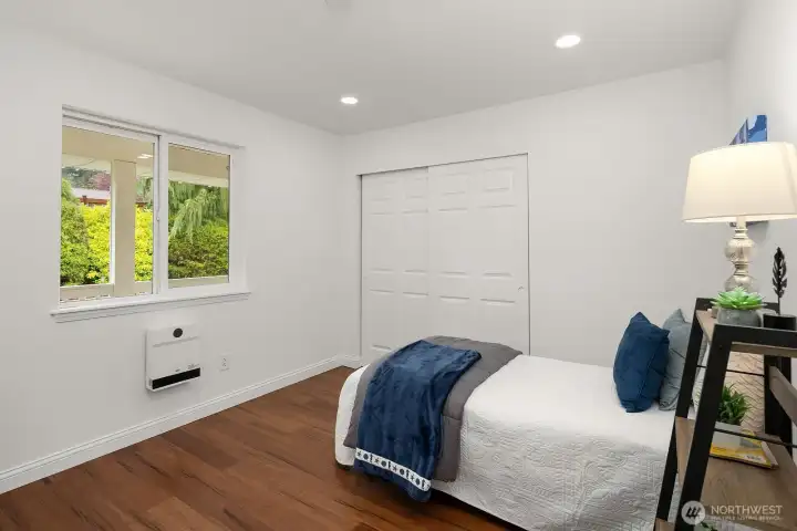 A third bedroom offers generous proportions, recessed lighting, a large closet, and bright windows with lush garden views, completing the well-appointed main level bedroom lineup in this move-in ready home.