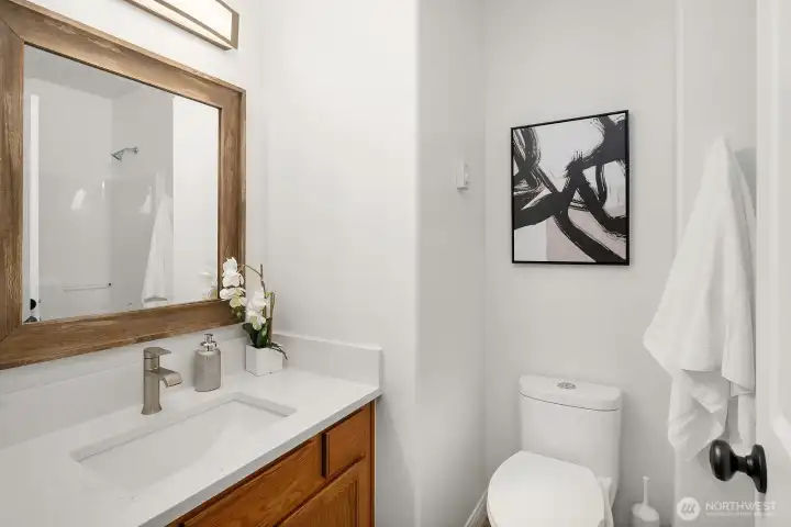 A well-appointed secondary bathroom features warm wood cabinetry, a clean white vanity, and tasteful finishes that carry the home's updated, move-in ready aesthetic throughout every corner of this exceptional property.