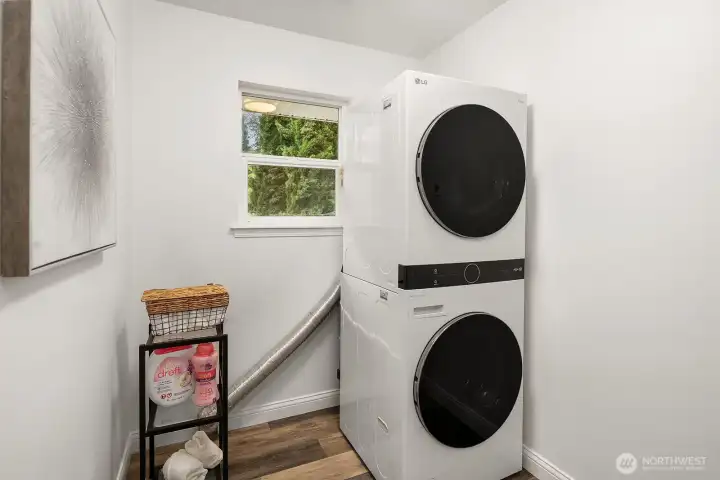 A dedicated laundry area with stacked washer and dryer tucks neatly into its own space, adding everyday convenience and practicality to this thoughtfully appointed, move-in ready home.