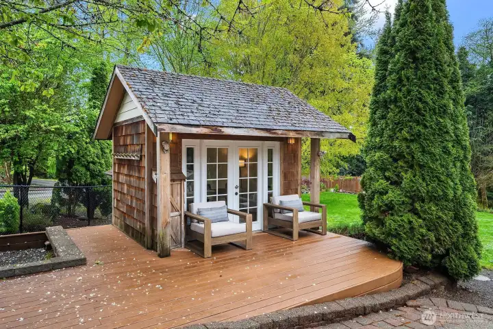 The charming outbuilding serves as a private office surrounded by its own deck, tucked among mature trees and lush landscaping — a rare and inspiring workspace that adds tremendous versatility and value to this exceptional property.