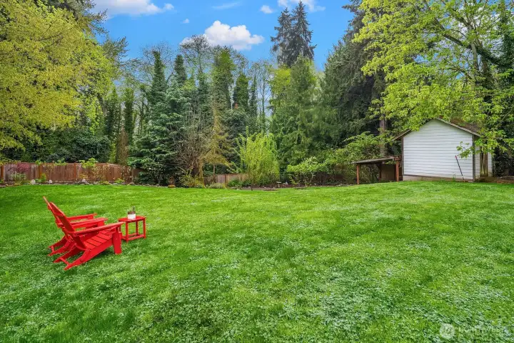 The expansive lawn stretches across the generous .771 acre lot, framed by mature apple, pear, cherry, and maple trees that lend the property a serene, estate-like quality rarely found so close to city amenities.