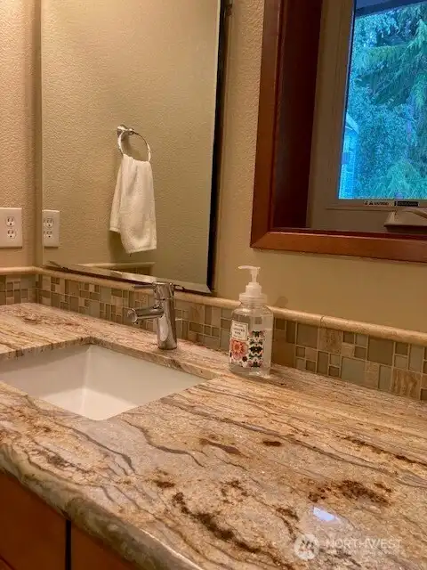 Wavey quartz counter top in full bathroom for the primary bed room.