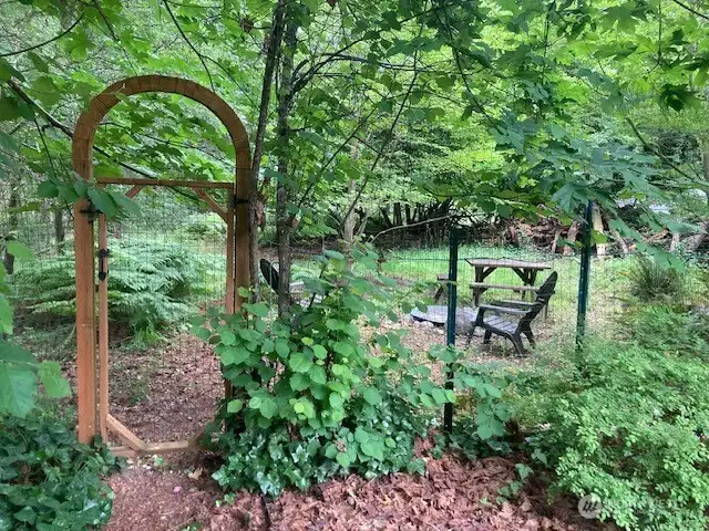 Arched gate to get to the treasured back woods.