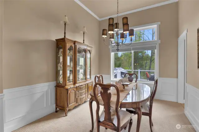Formal dining room with vaulted ceilings and wainscoting surround.