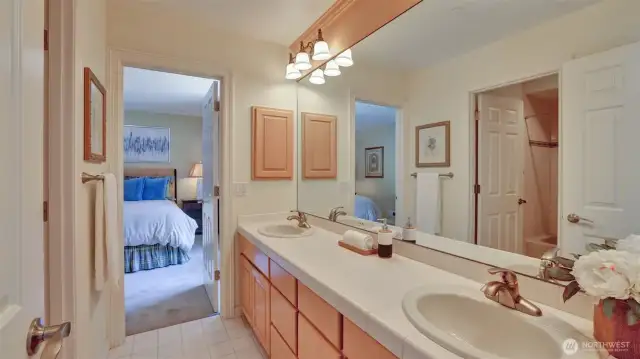 Jack and Jill bathroom with dual sinks and separate tub/toilet space