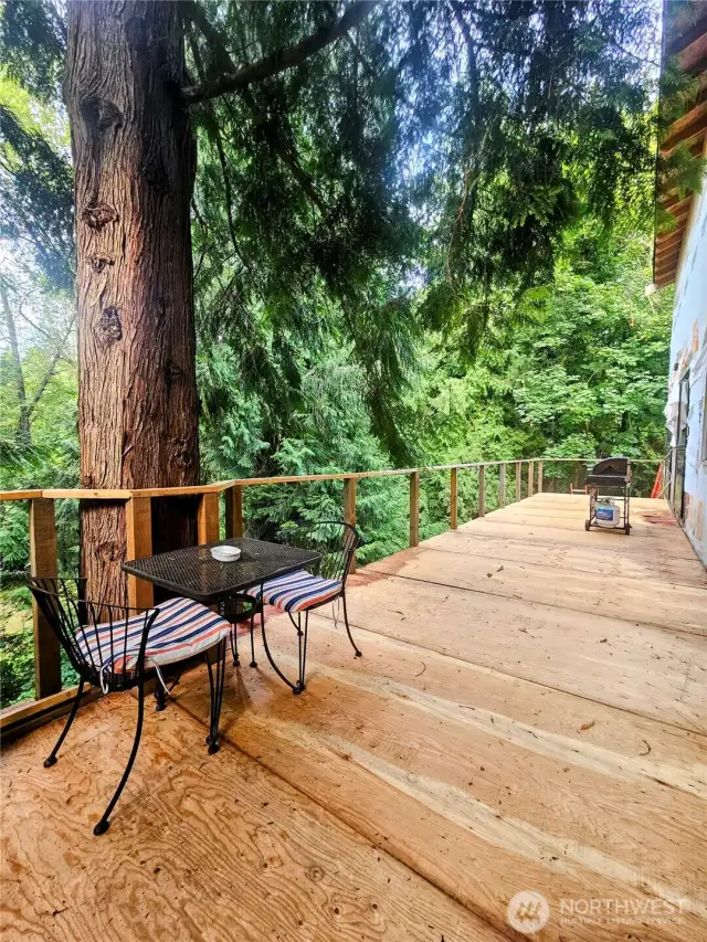 A spacious second-floor deck spans the entire back side of the home, offering peaceful views overlooking the creek—perfect for relaxing, entertaining, or simply enjoying the natural setting.