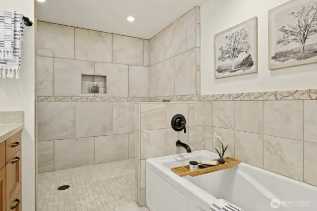 Deep soaking tub and custom tile work provides luxury