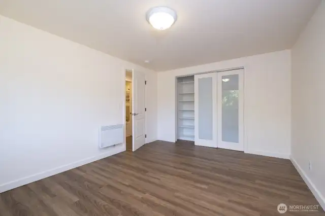 First bedroom with large closet area and attractive closet doors with built in shelving.  The luxury vinyl plank flooring is consistent from one room to the next - attractive, durable, easy to maintain, and no thresholds!