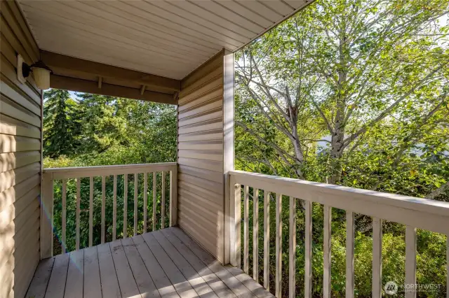Private balcony surrounded by trees.
