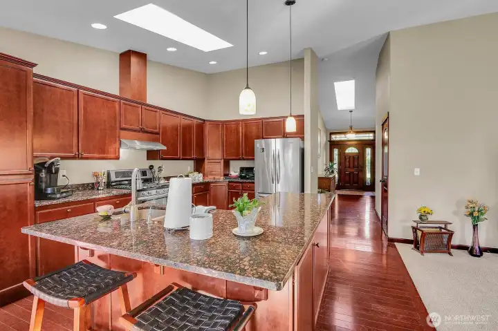 The kitchen shines with a skylight, breakfast bar, and abundant natural and overhead lighting.