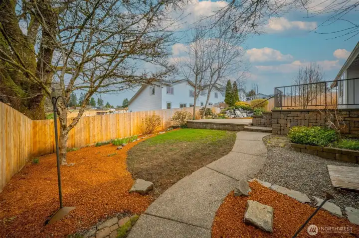 The well kept low maintenance yard continues around the side of the home.