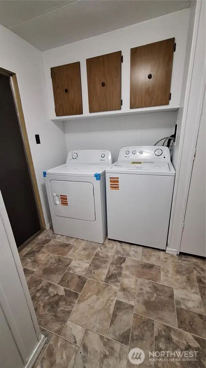 The covered deck covers both sliding door and utility room entrance. New flooring in the utility room plus new washer & dryer. Room for freezer or folding table.