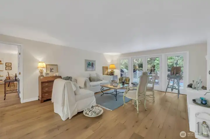 Family room with a wall of windows and French doors to the back deck and yard, indoor/outdoor living.
