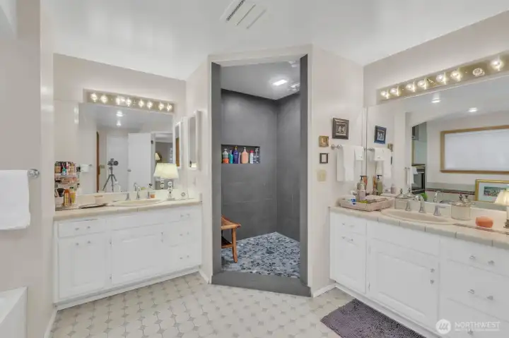 2 split vanities, large tiled shower with river rock floor, seperate toilet space, and a suana!