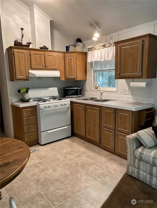 Kitchen area with enough cabinets and a propane gas range/oven.