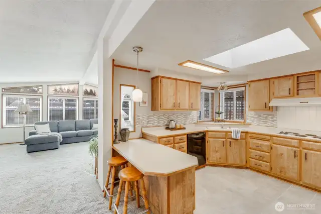 Kitchen features tile flooring, skylight & tile backsplash