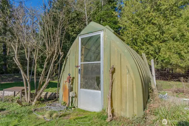 A small greenhouse inside one of the orchard/garden spaces