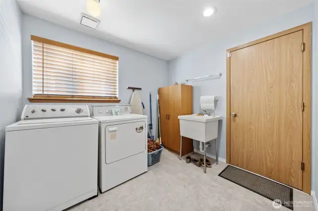Laundry room with mud sink and large window.