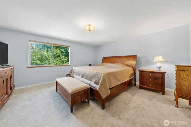 Primary bedroom with carpet, large window and .75 bath.
