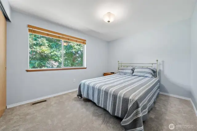 Bedroom with carpet and large window.